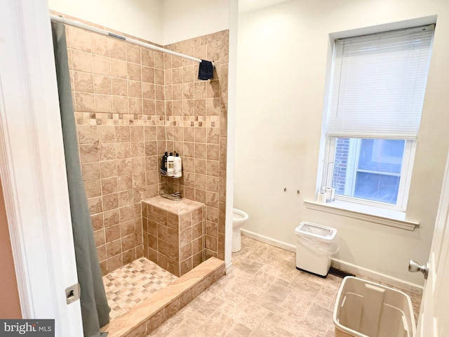 full bath with a stall shower, toilet, and baseboards