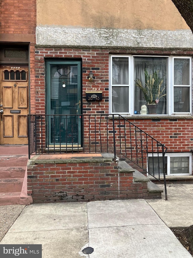 doorway to property with brick siding