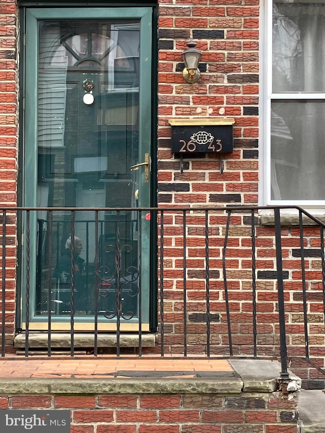 property entrance featuring brick siding