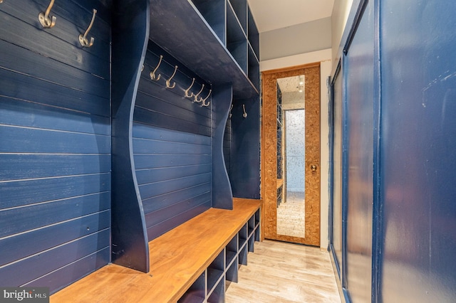 mudroom featuring wood walls and light wood-type flooring