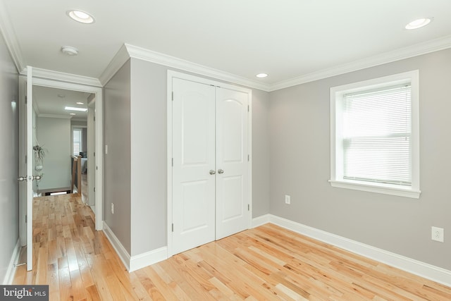 unfurnished bedroom with crown molding, recessed lighting, a closet, light wood-style flooring, and baseboards