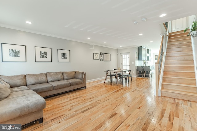 living area featuring crown molding, light wood finished floors, recessed lighting, visible vents, and stairs