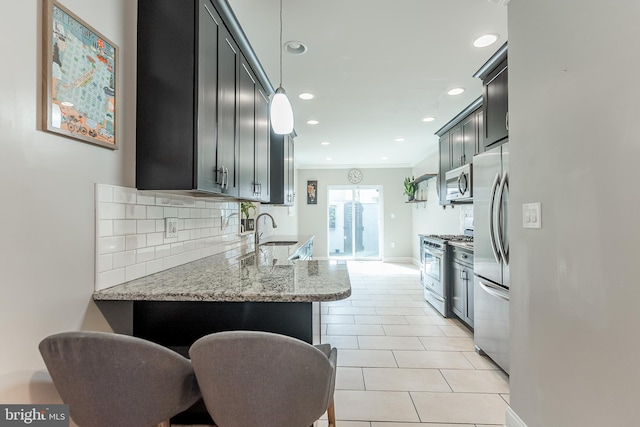 kitchen featuring light stone counters, crown molding, stainless steel appliances, tasteful backsplash, and a sink