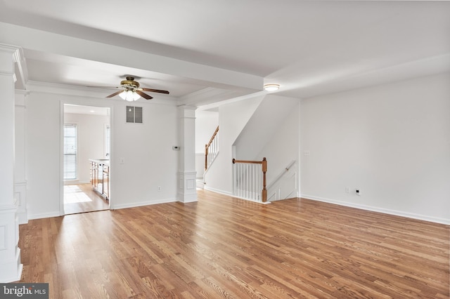 interior space featuring visible vents, baseboards, ornate columns, light wood finished floors, and crown molding