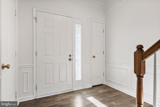 entryway featuring dark wood-style floors, a wainscoted wall, a decorative wall, stairway, and ornamental molding