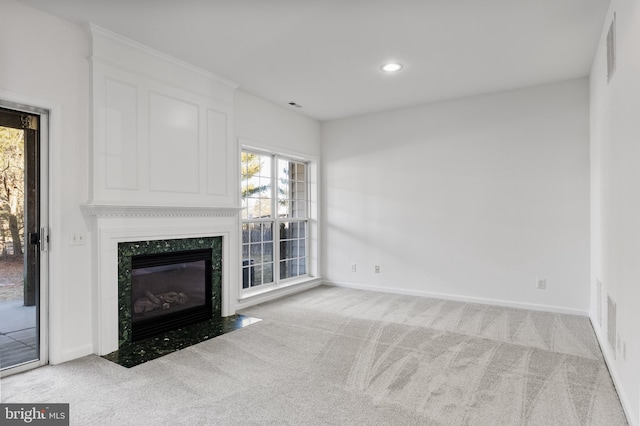 unfurnished living room with light carpet, a fireplace, and baseboards