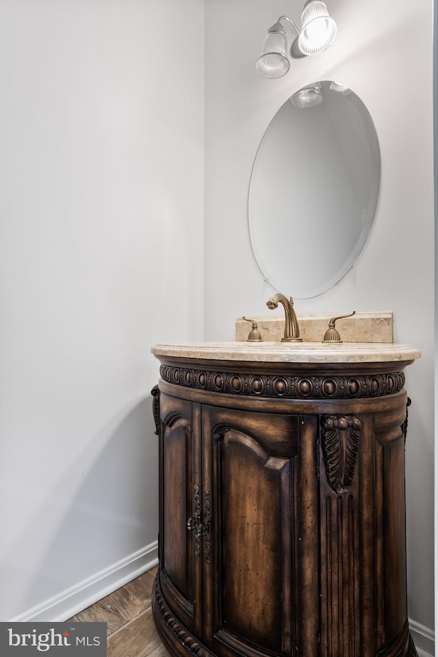 bathroom featuring wood finished floors, vanity, and baseboards