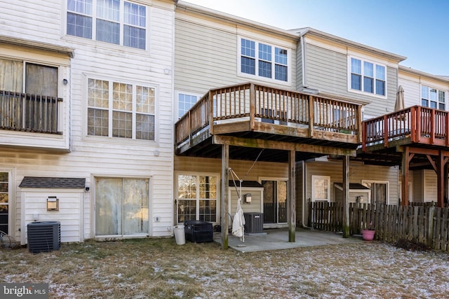 back of property featuring central air condition unit, a wooden deck, fence, and a patio