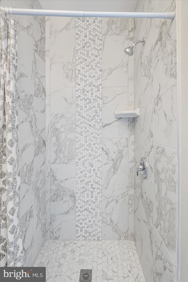 interior details featuring tiled shower