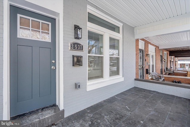 entrance to property featuring brick siding