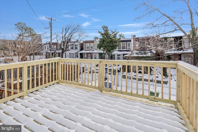 snow covered deck with a residential view