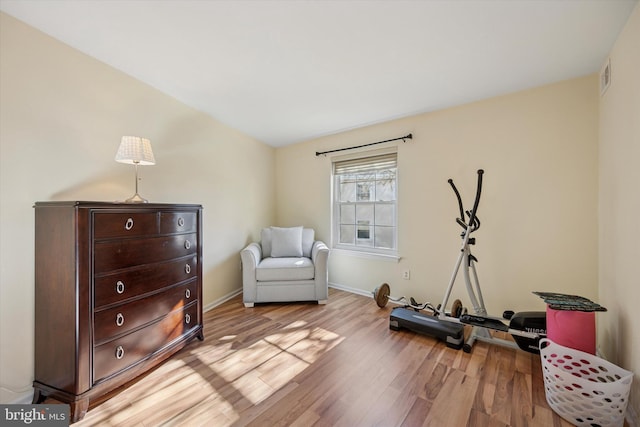 exercise area with baseboards and wood finished floors