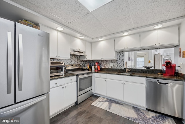 kitchen with stainless steel appliances, a sink, white cabinets, and under cabinet range hood