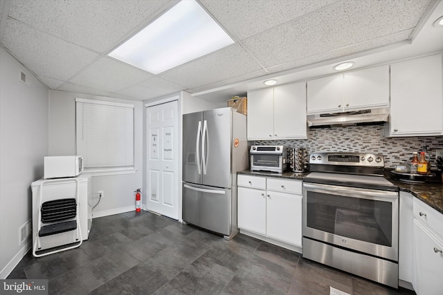 kitchen featuring dark countertops, under cabinet range hood, tasteful backsplash, and appliances with stainless steel finishes