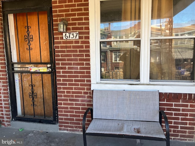 view of exterior entry with brick siding