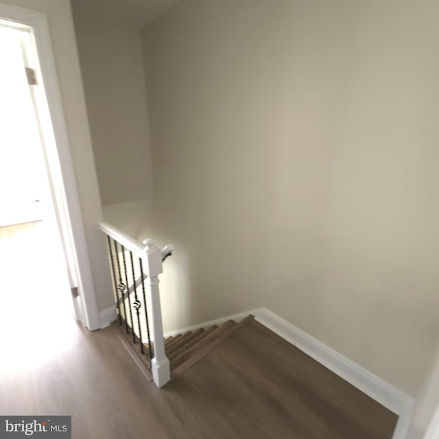 stairway with baseboards and wood finished floors