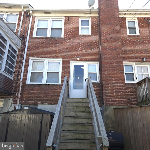 exterior space featuring brick siding and fence