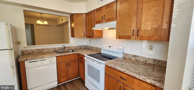 kitchen featuring brown cabinetry, white appliances, a sink, and under cabinet range hood