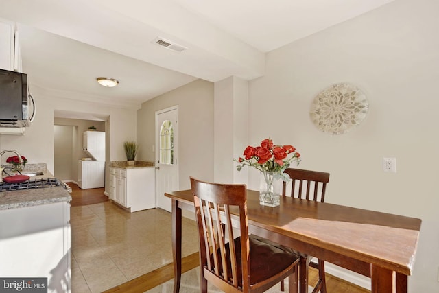 tiled dining area featuring visible vents