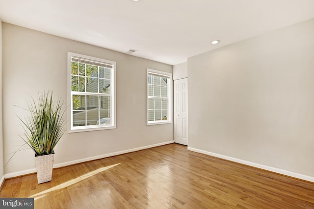 empty room featuring recessed lighting, baseboards, and wood finished floors