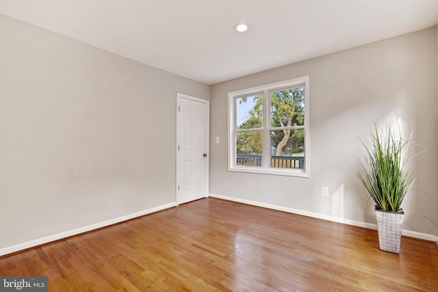 unfurnished room with light wood-style floors, baseboards, and recessed lighting