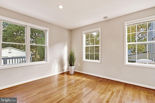 empty room with recessed lighting, visible vents, light wood-style flooring, and baseboards