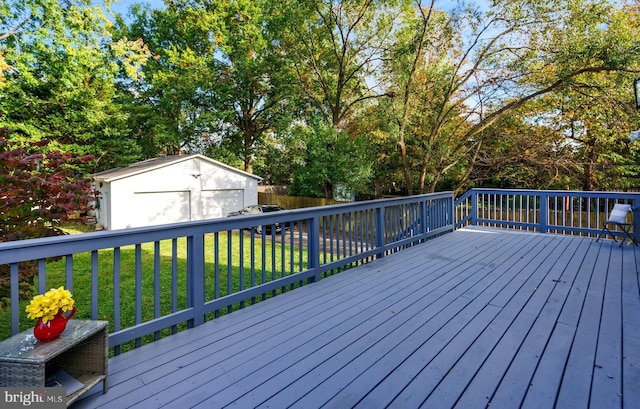 wooden deck with fence, a lawn, and an outbuilding