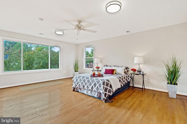 bedroom featuring wood finished floors, visible vents, and baseboards