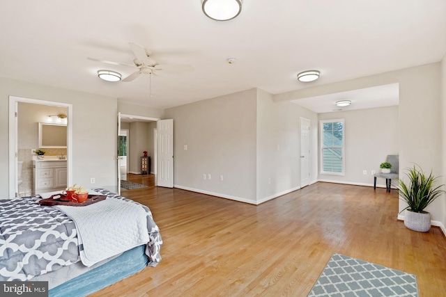 bedroom featuring light wood-style floors, baseboards, and connected bathroom