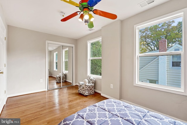 bedroom featuring visible vents, ceiling fan, baseboards, and wood finished floors