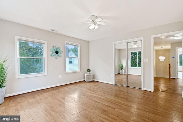 unfurnished room with a ceiling fan, baseboards, visible vents, and wood finished floors