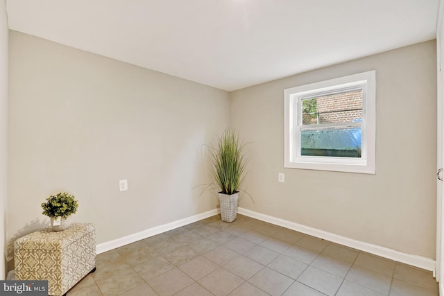 empty room featuring light tile patterned flooring and baseboards