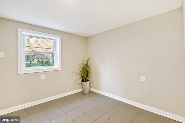 unfurnished room featuring baseboards and light tile patterned flooring