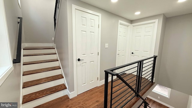 stairway with recessed lighting, baseboards, and wood finished floors