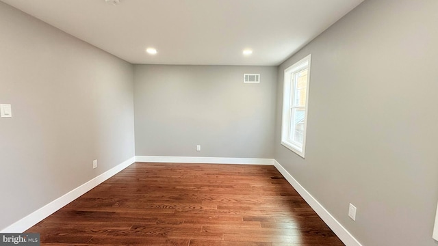 spare room with recessed lighting, wood finished floors, visible vents, and baseboards