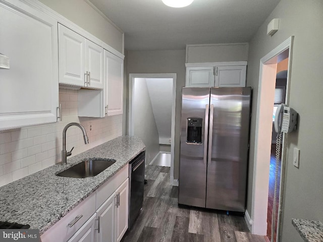 kitchen with white cabinetry, light stone counters, a sink, and stainless steel fridge with ice dispenser