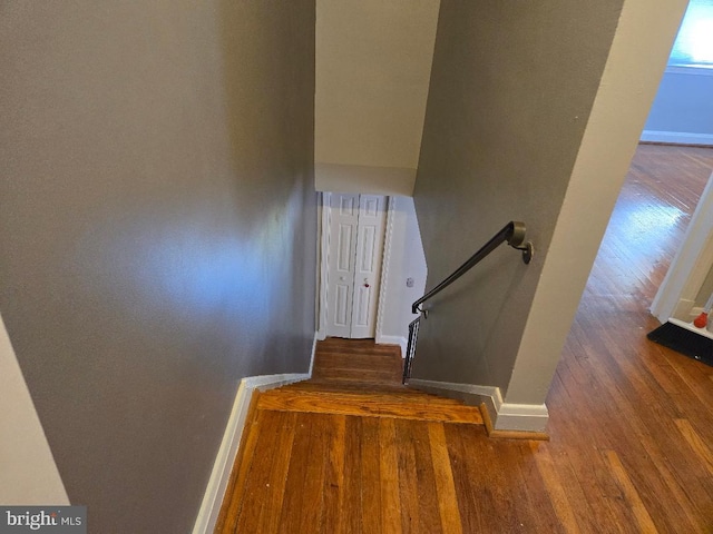 staircase with wood finished floors and baseboards