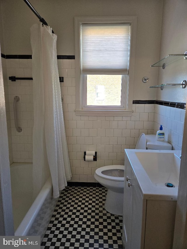 full bath with toilet, shower / tub combo with curtain, tile walls, and vanity