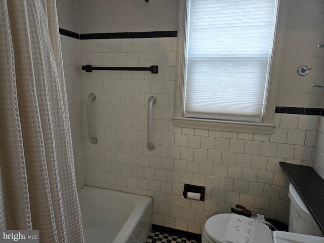 bathroom featuring tile walls and toilet