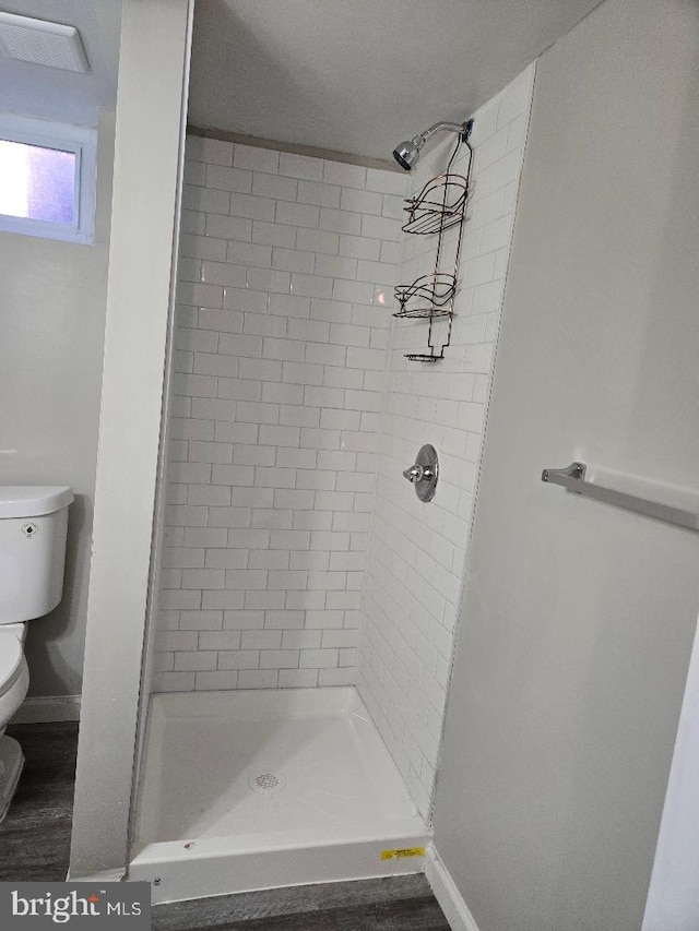 bathroom with toilet, a stall shower, visible vents, and baseboards