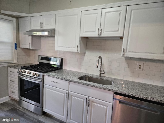 kitchen featuring stainless steel appliances, a sink, white cabinetry, and under cabinet range hood