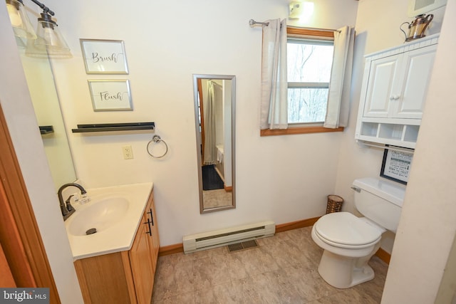 bathroom featuring a baseboard heating unit, toilet, vanity, and baseboards