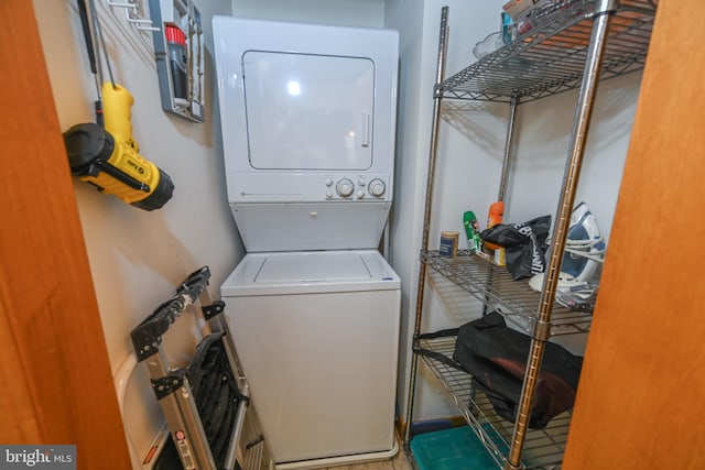 clothes washing area featuring stacked washer and dryer and laundry area