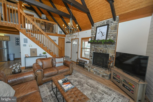 living area featuring high vaulted ceiling, a stone fireplace, wood finished floors, wood ceiling, and stairway