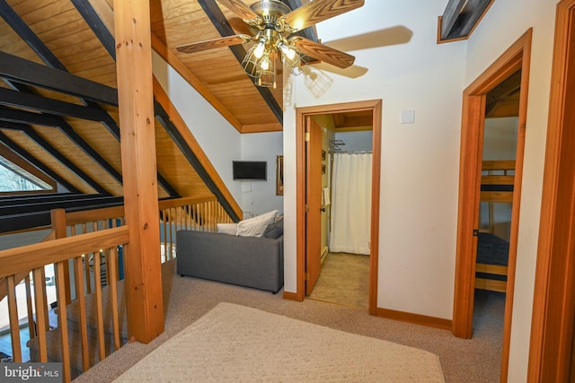 interior space with wood ceiling, baseboards, vaulted ceiling, and light colored carpet