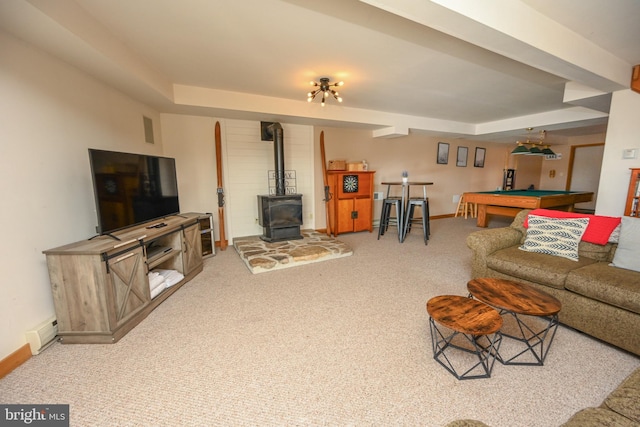 living room featuring pool table, a baseboard heating unit, a wood stove, carpet flooring, and baseboards