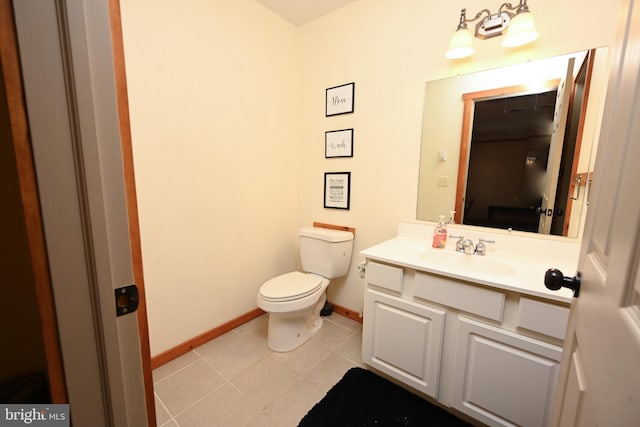 half bath featuring baseboards, vanity, toilet, and tile patterned floors