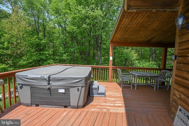 deck featuring outdoor dining space and a hot tub