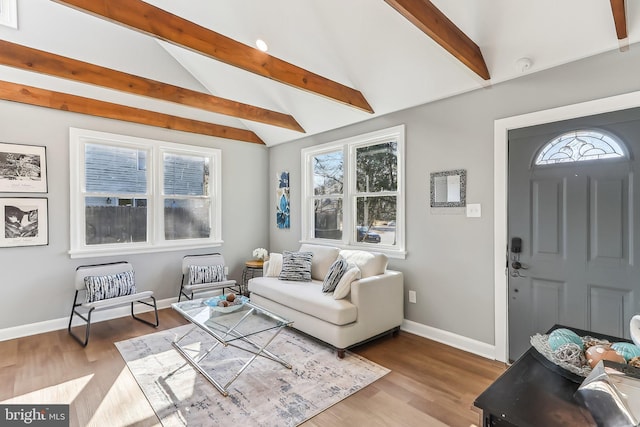 living room with light wood-type flooring, vaulted ceiling with beams, and baseboards