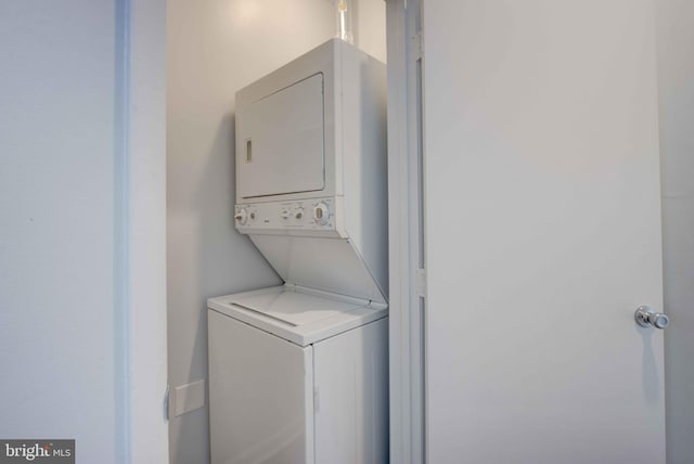 washroom with stacked washing maching and dryer